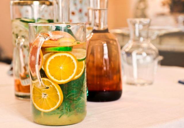 Carafe de citronnade au citron vert et à la menthe posée près de verres à l'apéritif